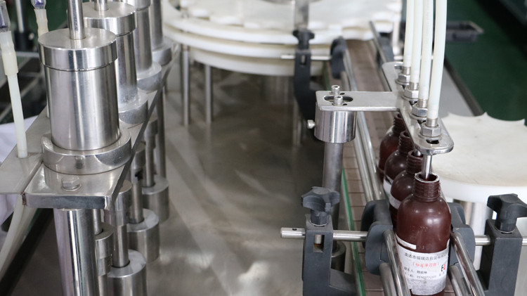 Máquina de recheo de botellas redondas de 500ml con selado de tapa e roda de estrelas en marcha